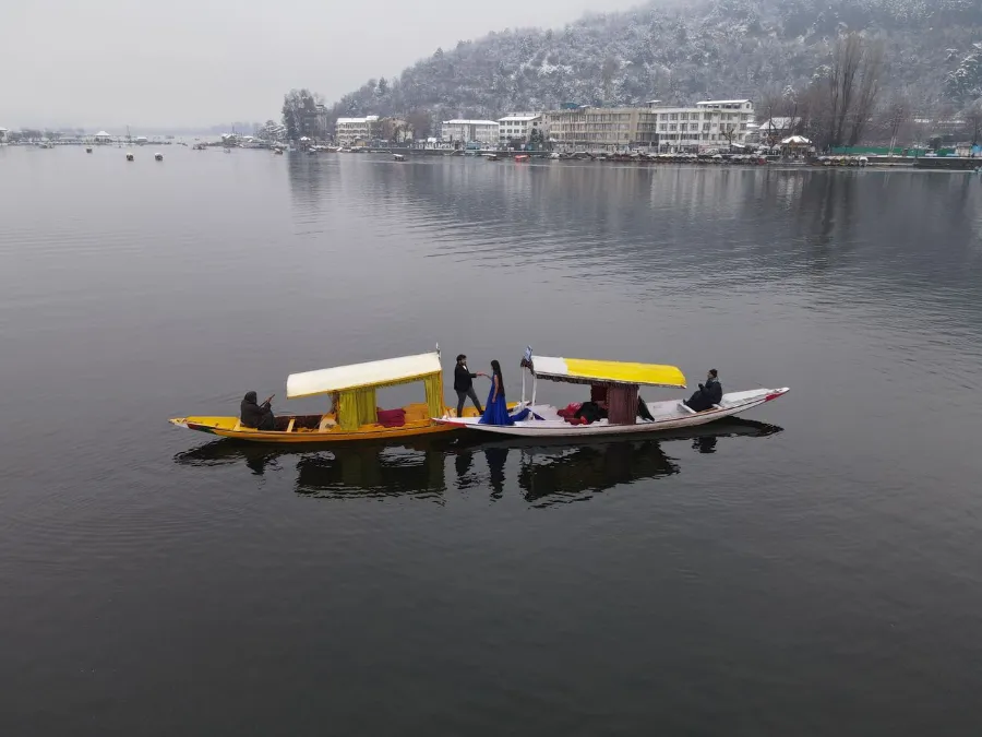 Couple enjoying a romantic shikara ride on a serene winter lake in Srinagar