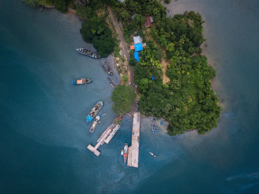 Drone capture of Port Blair docks and boats against lush greenery and calm sea